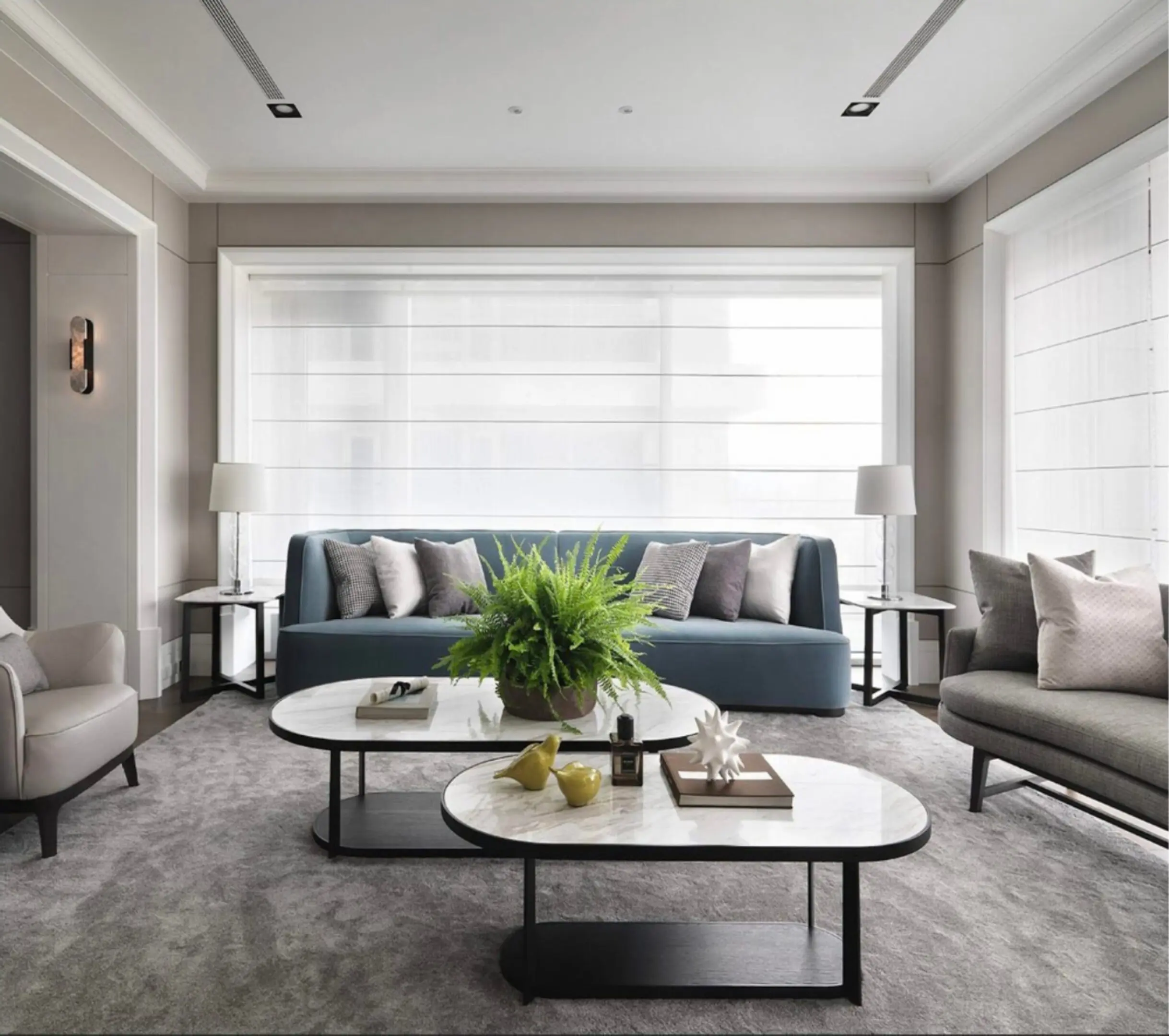 Modern living room with neutral tones and a large window.