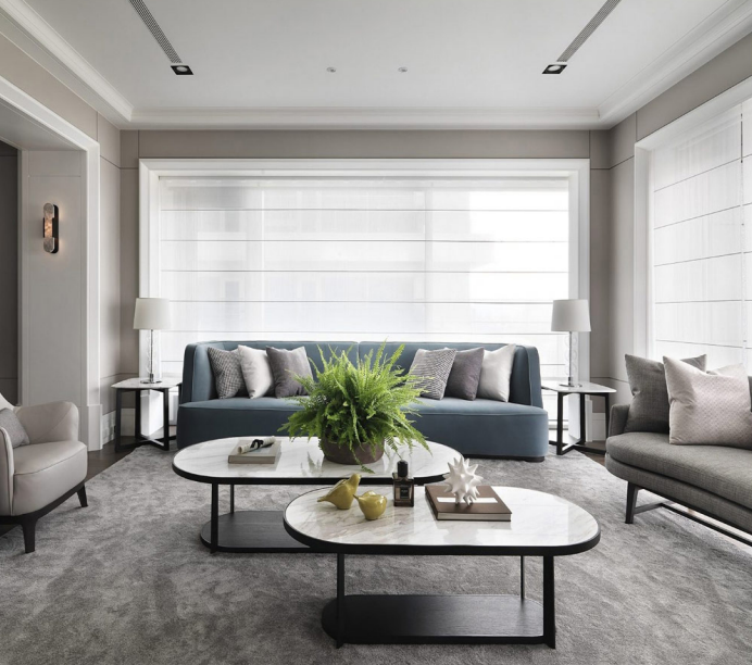 Modern living room with neutral tones and large windows.