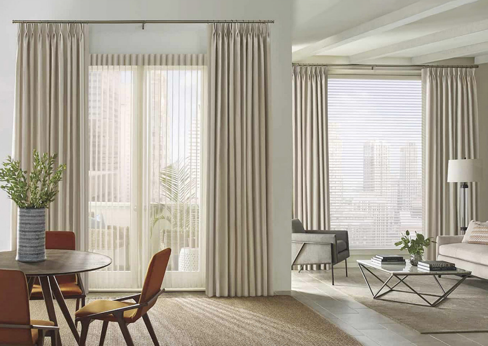 Modern living room with large windows and sheer curtains.