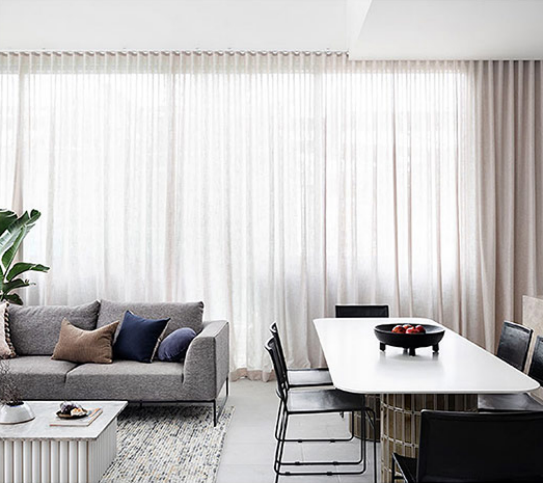 Modern living room and dining area with minimalist design and neutral tones.