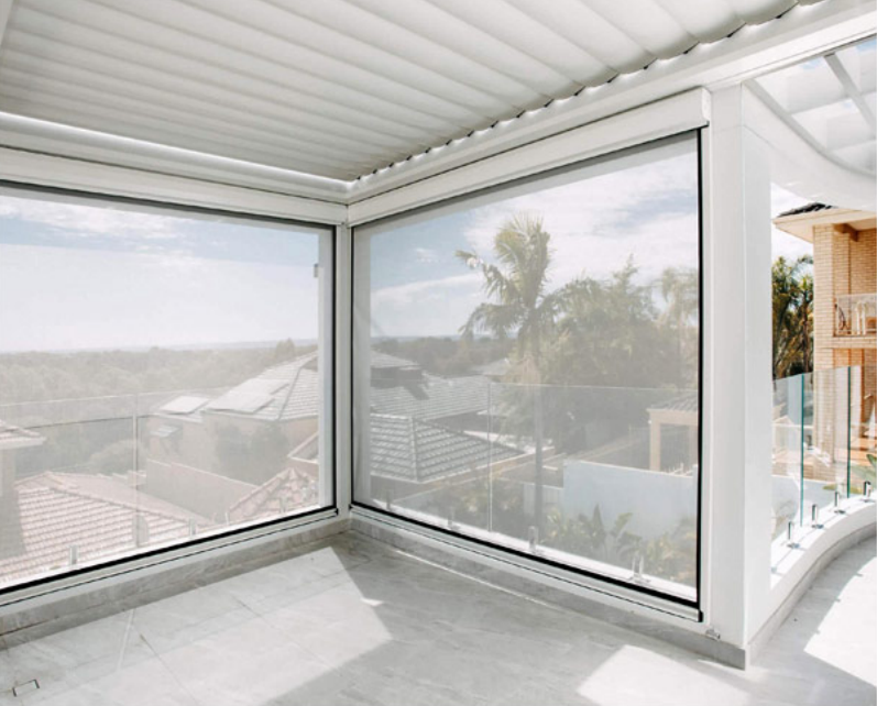 Modern sunroom with glass walls and scenic outdoor view.